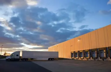 Truck trailer at warehouse loading dock for fleet rental logistics