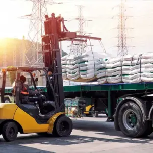 Forklift loading material onto a flatbed truck