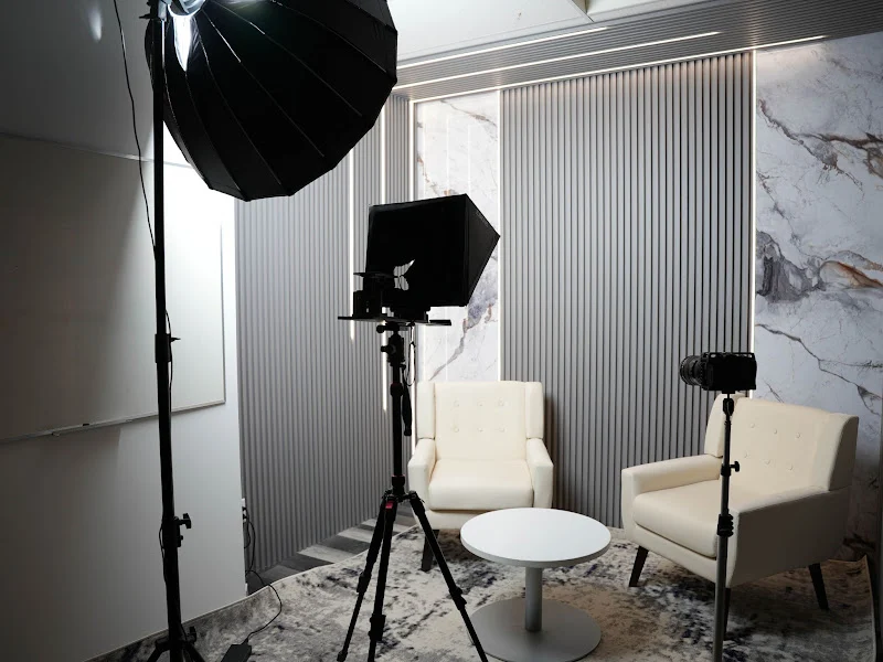 Grey-panel podcast studio set up with camera, teleprompter and studio lighting