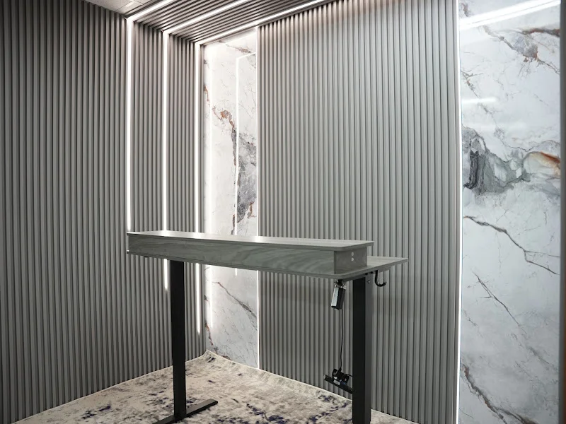 Grey-panel podcast studio with a standing desk and marble accent walls